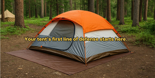 A waterproof tent footprint placed under a dome tent in a forest campsite, protecting it from dirt, rocks, and ground moisture.
